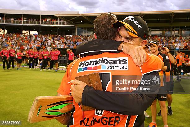Justin Langer, head coach of the Scorchers embraces Michael Klinger after winning the Big Bash League match between the Perth Scorchers and the...