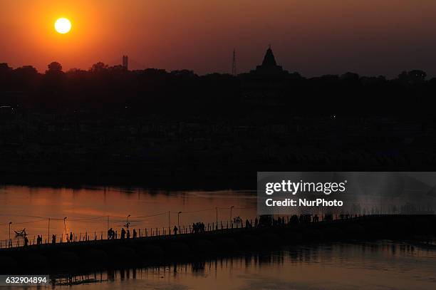 Indian hindu devotees return on a temporary pantoon tank bridge, after taking a holy dip at sangam, confluence of three rivers Ganges, Yamuna and...