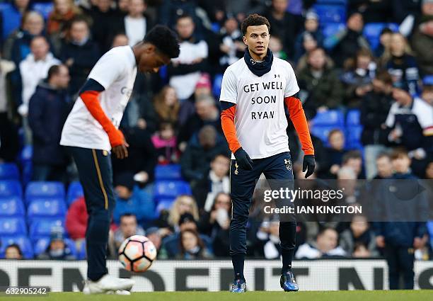 Tottenham Hotspur's English midfielder Dele Alli and teammates wear t-shirts reading "Get Well Soon Ryan", realting to Hull City's Ryan Mason, as...