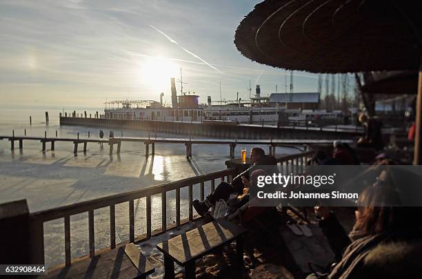 Visitors enjoy sitting in the sun in front of Lake Ammersee on January 28, 2017 in Stegen am Ammersee, Germany. After an unusual cold winter period...