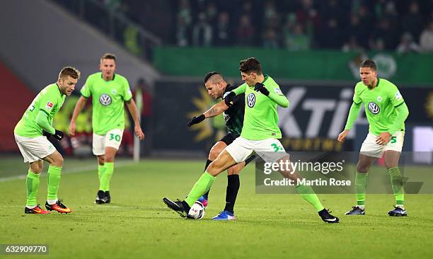 Mario Gomez of Wolfsburg and Raul Bobadilla of Augsburg battle for the ball during the Bundesliga match between VfL Wolfsburg and FC Augsburg at...