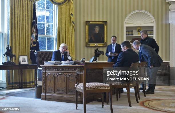 President Donald Trump speaks on the phone with Russia's President Vladimir Putin from the Oval Office of the White House on January 28 in...