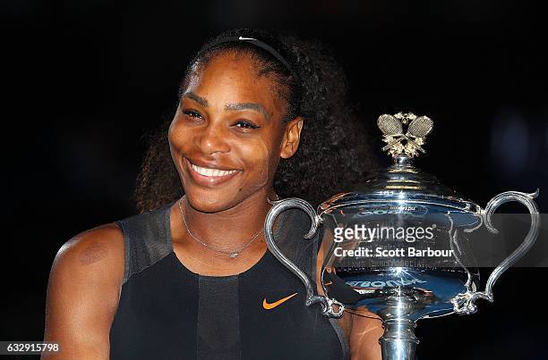 Serena Williams poses with the Daphne Akhurst Trophy after winning the Women's Singles Final against Venus Williams of the United States on day 13 of...