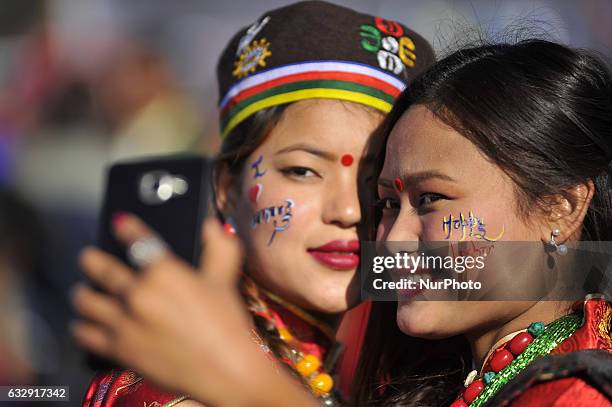 Girls in a traditional attire takes pictures from mobile phone during celebration of Sonam Losar festival or Lunar New Year, which occurs around the...