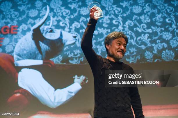 Japanese filmaker Kiyoshi Kurosawa holds his trophy after being awarded for his carrer during the 24th Gerardmer fantastic film festival on January...