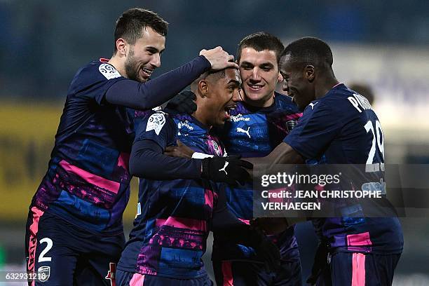 Bordeaux's Brazilian forward Malcom Silva de Oliveira is congratulated by his teammates after scoring a goal during the French L1 football match...