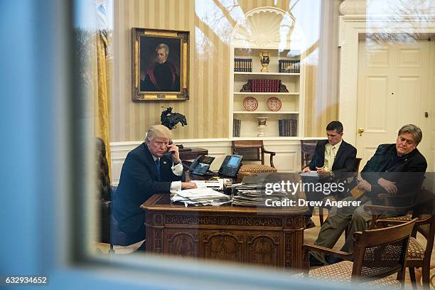 President Donald Trump speaks on the phone with Australian Prime Minister Malcolm Turnbull in the Oval Office of the White House, January 28, 2017 in...