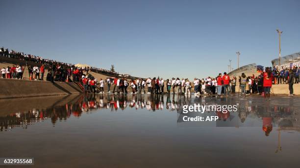 Group of Mexicans are pictured during an event called "Hugs, No Walls" in front of the border fence that separates Mexico from the US, in Ciudad...