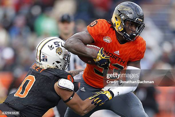 Kareem Hunt of the North team runs with the ball as Duke Riley of the South team defends during the second half of the Reese's Senior Bowl at the...