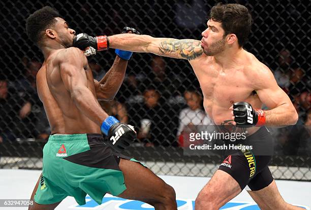 Raphael Assuncao of Brazil punches Aljamain Sterling in their bantamweight bout during the UFC Fight Night event at the Pepsi Center on January 28,...
