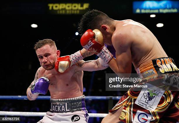 Carl Frampton gets hit with a punch from Leo Santa Cruz during the 12th round of their WBA featherweight title fight at MGM Grand Garden Arena on...