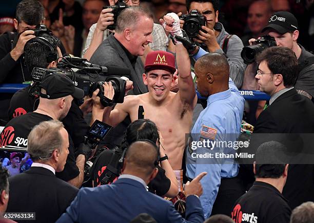 Kenny Bayless holds up Leo Santa Cruz's hand after he was announced as the winner by majority decision in his WBA featherweight title fight against...