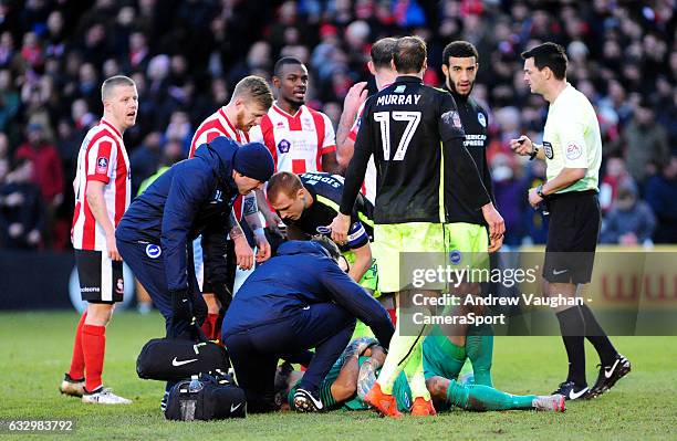 Brighton & Hove Albion's Niki Maenpaa receives treatment before leaving the pitch injured during the Emirates FA Cup Fourth Round match between...