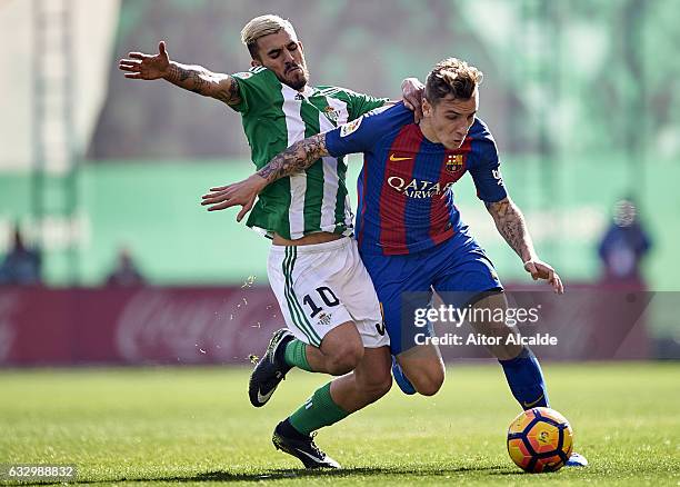 Dani Ceballos of Real Betis Balompie competes for the ball with Lucas Digne of FC Barcelona during the La Liga match between Real Betis Balompie and...