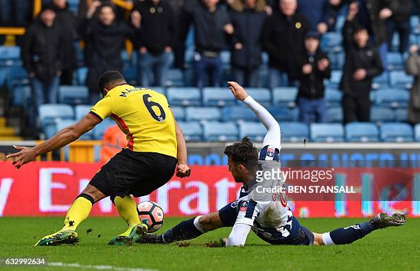 Millwall's English striker Lee Gregory and Watford's English-born Jamaican defender Adrian Mariappa compete for the ball in a goal-mouth scramble...