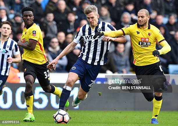 Millwall's English-born Welsh striker Steve Morison vies with Watford's French midfielder Adlene Guedioura during the English FA Cup fourth round...