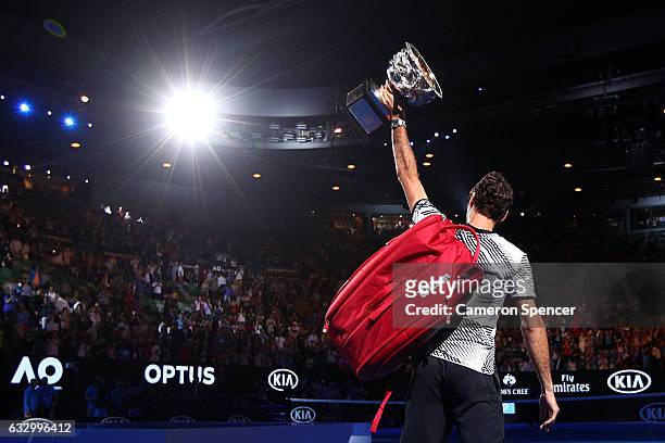 Roger Federer of Switzerland walks off court with the Norman Brookes Challenge Cup after winning the Men's Final match against Rafael Nadal of Spain...