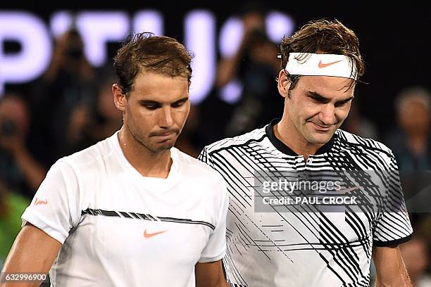 Switzerland's Roger Federer walks off the court with Spain's Rafael Nadal after winning their men's singles final match on day 14 of the Australian...