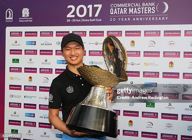 Jeunghun Wang of South Korea celebrates with the trophy following his victory in the playoff during the fourth round of the Commercial Bank Qatar...