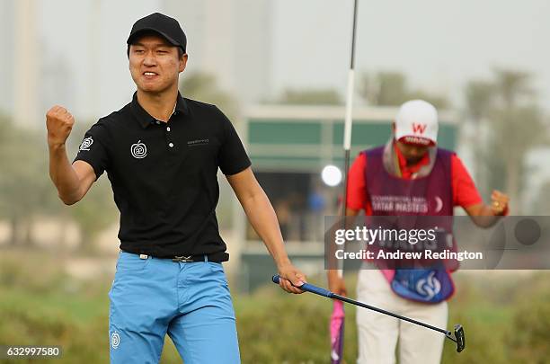 Jeunghun Wang of South Korea and his caddie Dongwoo Ko celebrate his victory in the playoff during the final round of the Commercial Bank Qatar...