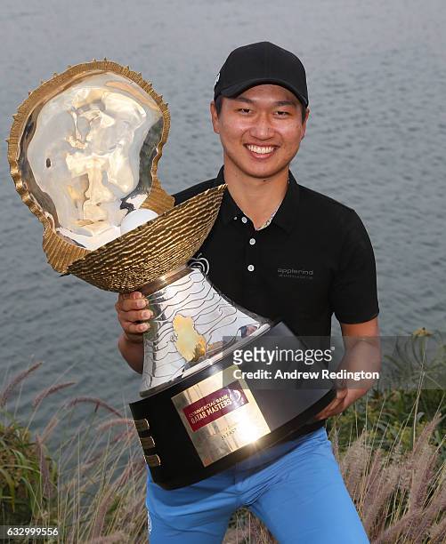 Jeunghun Wang of South Korea poses with the trophy following his victory in the playoff during the fourth round of the Commercial Bank Qatar Masters...