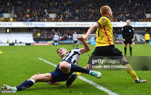 Millwall's English-born Welsh striker Steve Morison vies with Watford's English midfielder Ben Watson during the English FA Cup fourth round football...