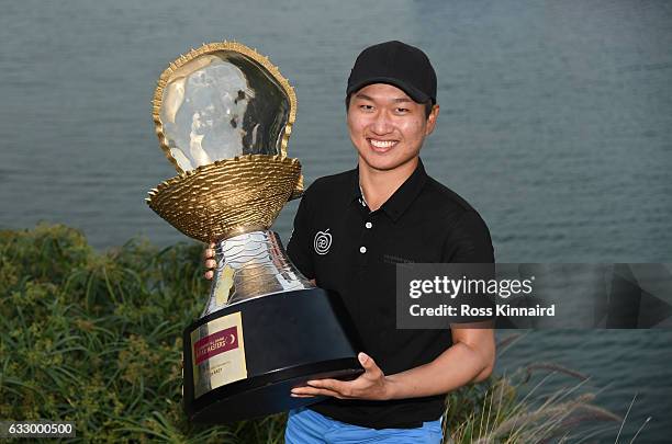 Jeunghun Wang of South Korea poses with the trophy following his victory in the playoff during the fourth round of the Commercial Bank Qatar Masters...