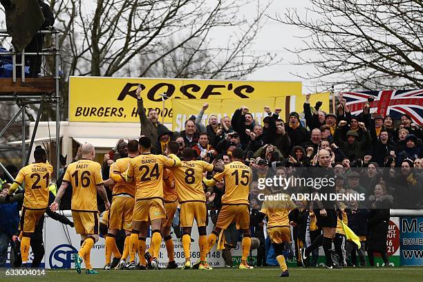 Sutton United's English defender Jamie Collins celebrates with teammates after scoring the opening goal from the penalty spot during the English FA...