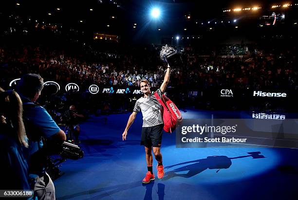 Roger Federer of Switzerland waves to fans in the crowd as he does a victory lap of the court with the Norman Brookes Challenge Cup after winning the...