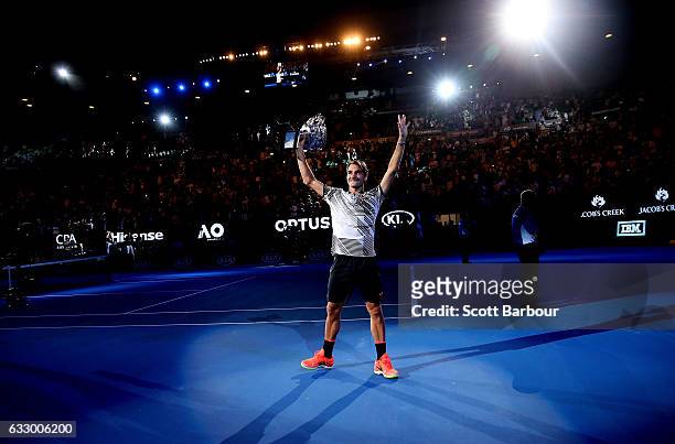 Roger Federer of Switzerland waves to fans in the crowd as he does a victory lap of the court with the Norman Brookes Challenge Cup after winning the...