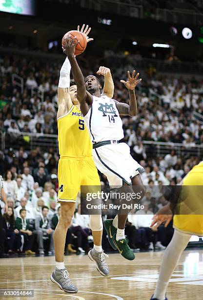 Eron Harris of the Michigan State Spartans goes for layup against D.J. Wilson of the Michigan Wolverines at the Breslin Center on January 29, 2017 in...