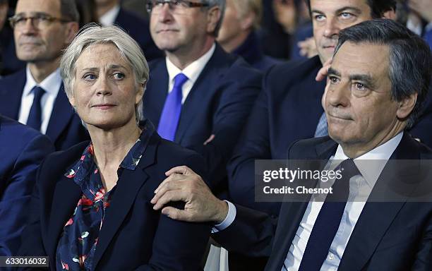 Former French prime minister and member of right-wing political party 'Les Republicains' Francois Fillon reacts as he touches his wife Penelope...