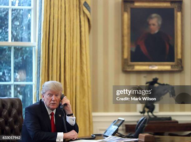 President Donald Trump is seen through a window speaking on the phone with King of Saudi Arabia, Salman bin Abd al-Aziz Al Saud, in the Oval Office...