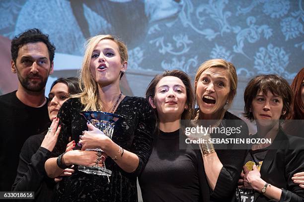 French filmmaker Julia Ducournau holds her trophy next to French actresses Garance Marillier , Julie Gayet , member of pop band Aaron, Olivier...