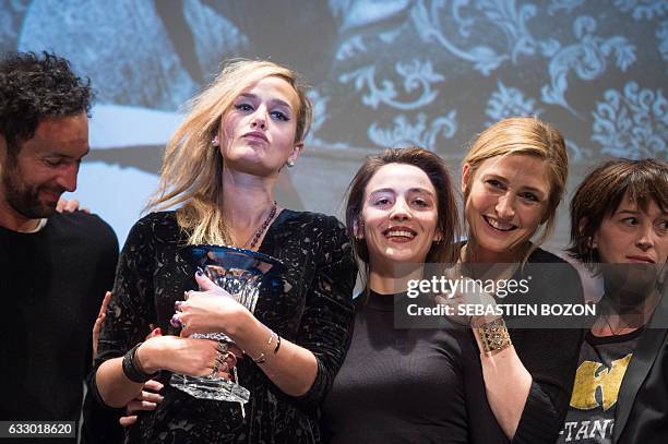 French filmmaker Julia Ducournau holds her trophy next to French actresses Garance Marillier , Julie Gayet , member of pop band Aaron, Olivier...