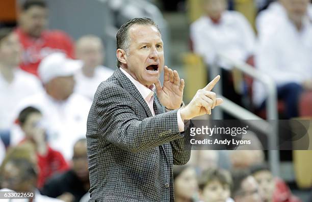 Mark Gottfried the head coach of the North Carolina State Wolfpack gives instructions to his team during the game against the Louisville Cardinals at...
