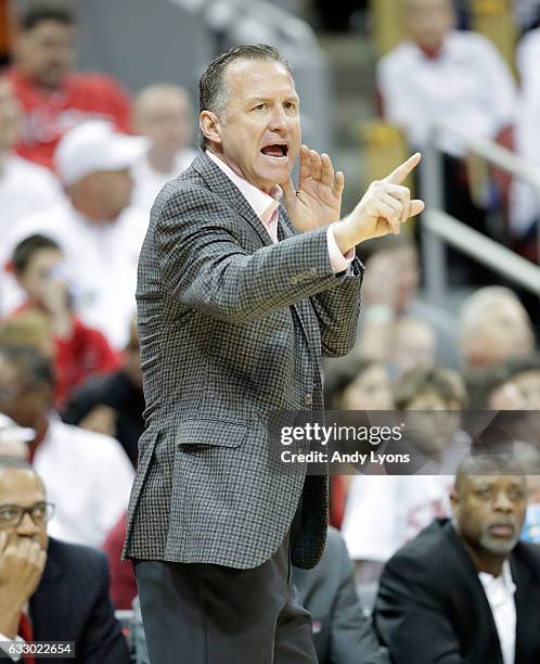 Mark Gottfried the head coach of the North Carolina State Wolfpack gives instructions to his team during the game against the Louisville Cardinals at...