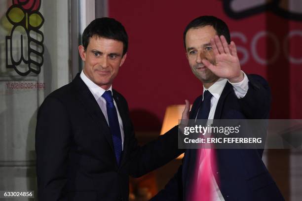 Winner of the left-wing primaries ahead of France's 2017 presidential elections Benoit Hamon gestures next to defeated candidate Manuel Valls...