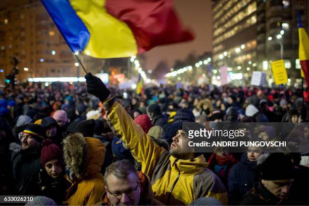 Man holds a Romanian national flag during a demonstration to protest against controversial decrees to pardon corrupt politicians and decriminalise...