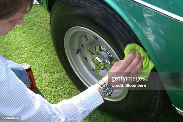 Vehicle handler polishes the tire of a a 1967 Ferrari SpA 330 GTC Speciale sports vehicle during the 26th Annual Cavallino Classic Event at the...