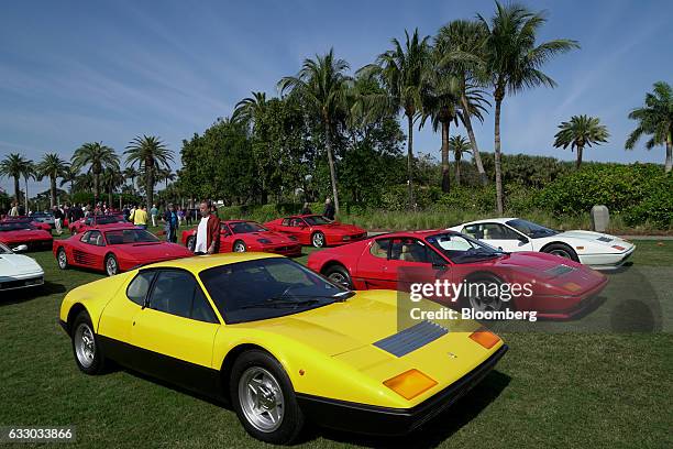 Attendees walk past Ferrari SpA vehicles on display during the 26th Annual Cavallino Classic Event at the Breakers Hotel in Palm Beach, Florida,...