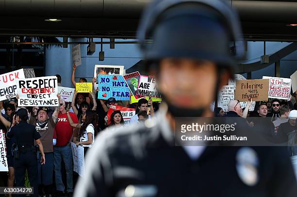 Protesters hold signs during a demonstration against the immigration ban that was imposed by U.S. President Donald Trump at Los Angeles International...