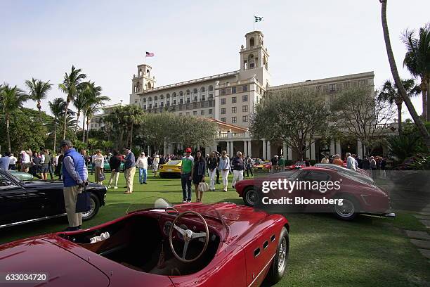 Attendees walk past Ferrari SpA vehicles on display during the 26th Annual Cavallino Classic Event at the Breakers Hotel in Palm Beach, Florida,...