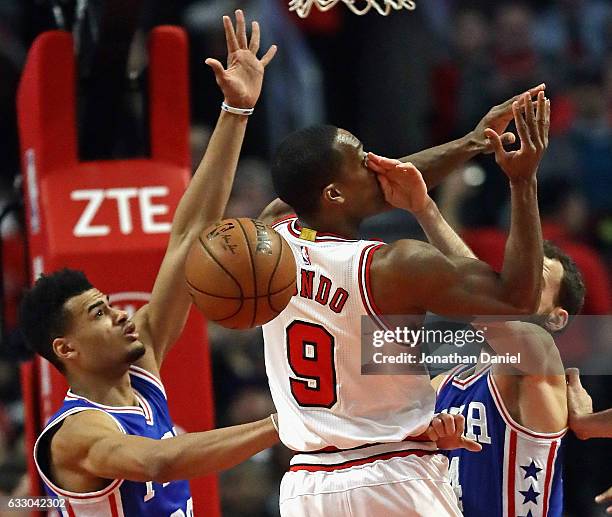 Rajon Rondo of the Chicago Bulls looses control of the ball after being hit in the face by Sergio Rodriguez of the Philadelphia 76ers as Timothe...