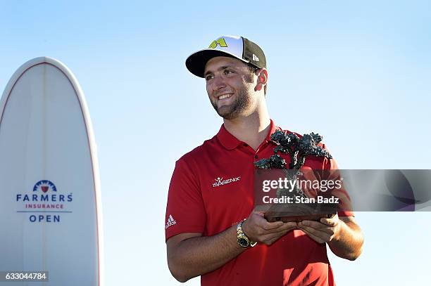 Jon Rahm of Spain poses with his trophy on the 18th hole during the final round of the Farmers Insurance Open at Torrey Pines South Golf Course on...