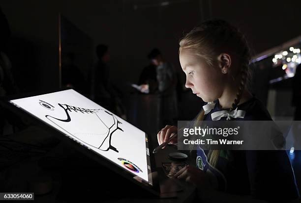 Fans draw custom designed football uniforms on Microsoft Surface Pro screens at the NFL Experience on January 29, 2017 in Houston, Texas.