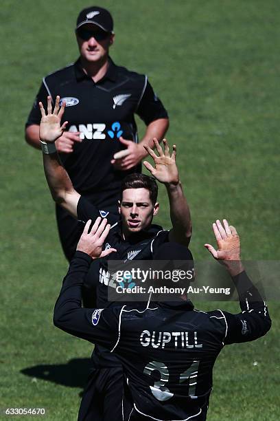 Mitchell Santner celebrates with teammates for the wicket of Shaun Marsh of Australia during the first One Day International game between New Zealand...