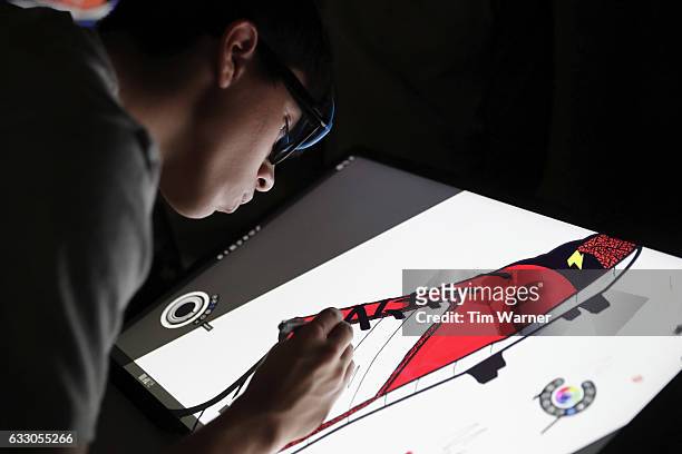 Fans draw custom designed football uniforms on Microsoft Surface Pro screens at the NFL Experience on January 29, 2017 in Houston, Texas.