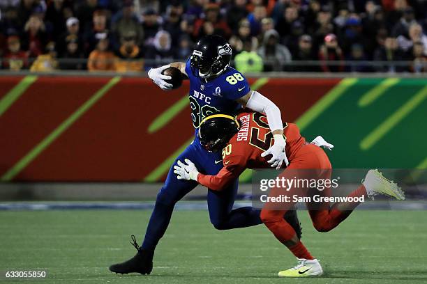 Jimmy Graham of the NFC tries to avoid the tackle of Ryan Shazier of the AFC in the first half during the NFL Pro Bowl at the Orlando Citrus Bowl on...