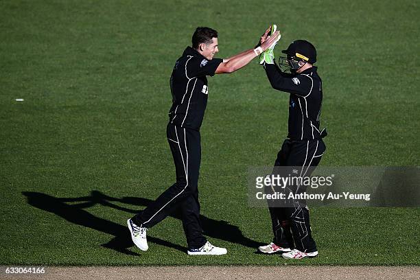 Mitchell Santner and Tom Latham of New Zealand celebrate taking the wicket of Pat Cummins of Australia during the first One Day International game...